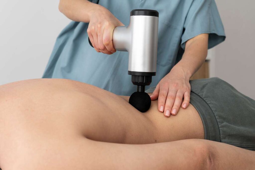 personne utilisant un pistolet de massage 11zon